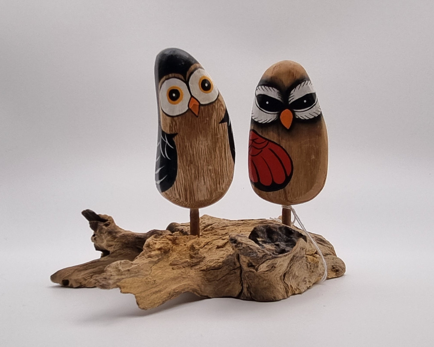 2 houtgesneden vogels op houten ondergrond